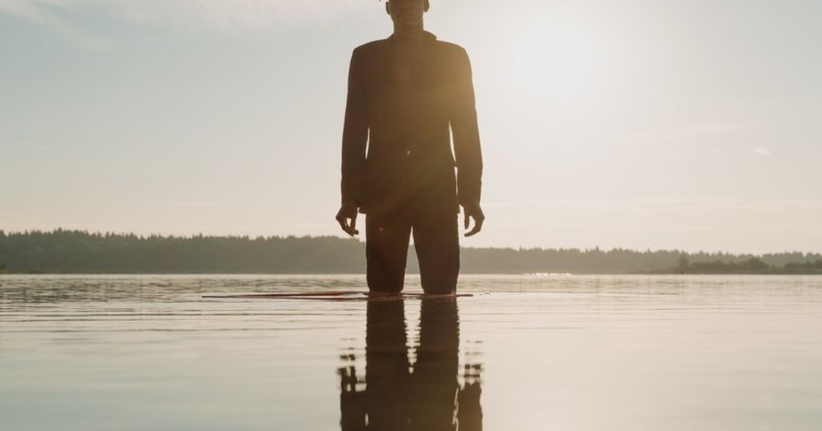 Person standing quietly in soft natural light